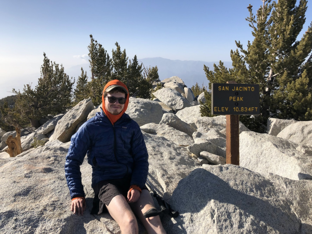 Me next to the plaque at the top of Mt San Jacinto