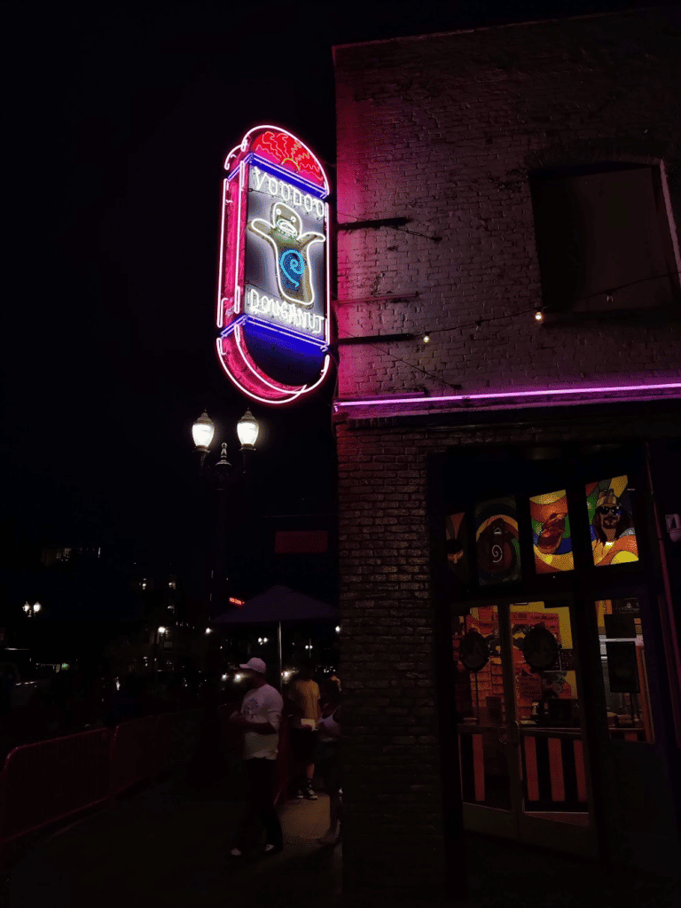 lit up sign of Voodoo Doughnuts at night