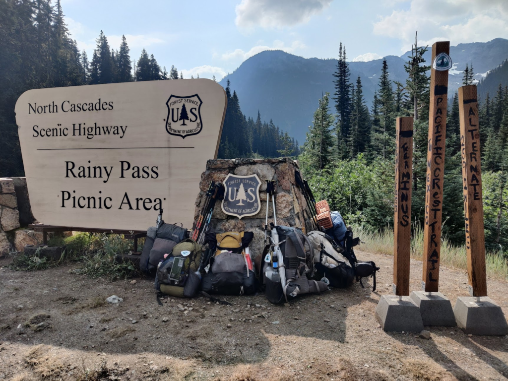 Rainy Pass sign with our backpacks underneath